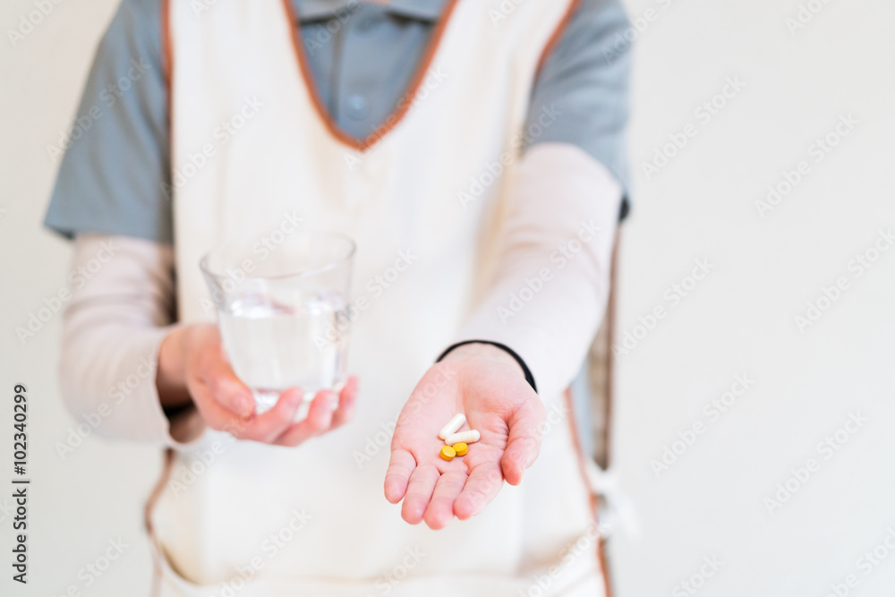 薬を差し出すヘルパー 薬を差し出すヘルパー