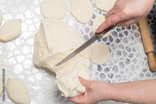 cutting the dough with a knife in the kitchen