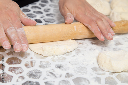 sheeting the dough with a rolling pin in the kitchen