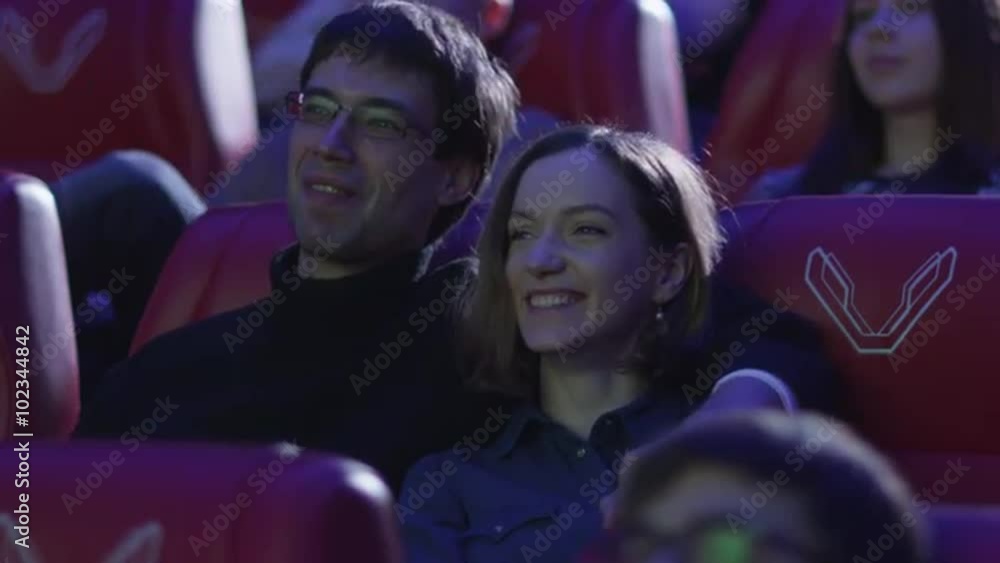 Young happy romantic couple is watching a film screening in a movie cinema theater. Shop on RED Cinema Camera. Young happy romantic couple is watching a film screening in a movie cinema theater. Shop on RED Cinema Camera.