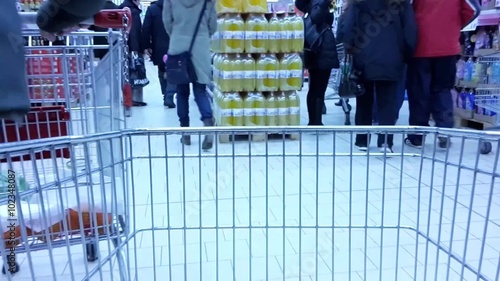 Time-lapse movie with shopping cart in discount market moving around shelves of fruit, vegetables, drinks. Timelapse on market sale.