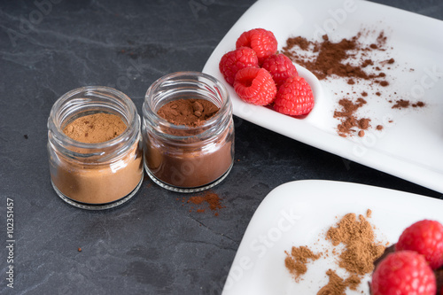 Pasteles de chocolate con frambuesas y tarritos de cacao