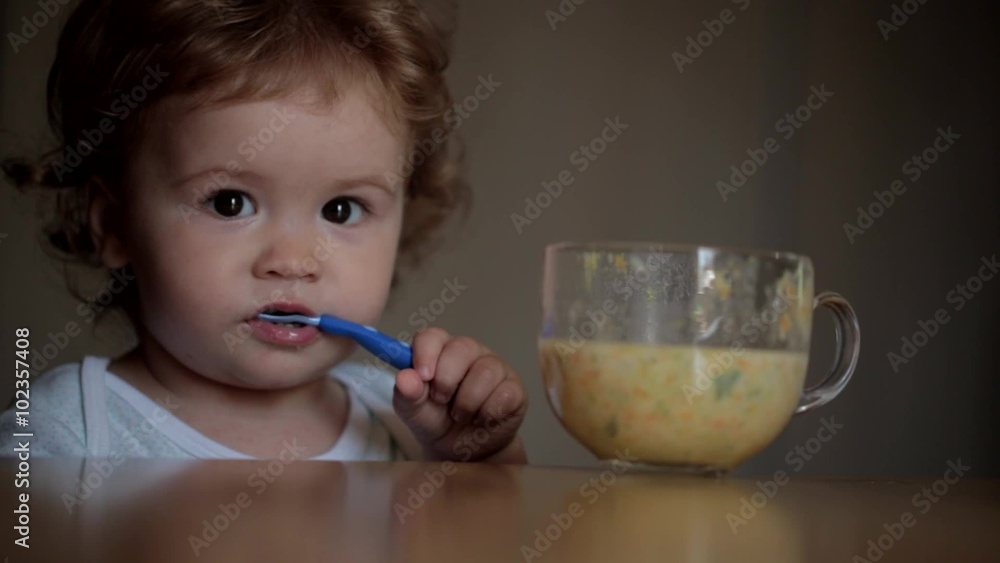 Beautiful curly-haired child eats at the table Beautiful curly-haired child eats at the table