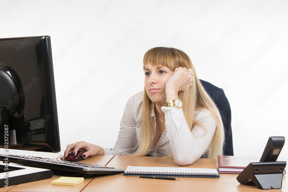 Office worker looking blankly at the computer screen in the office Office worker looking blankly at the computer screen in the office