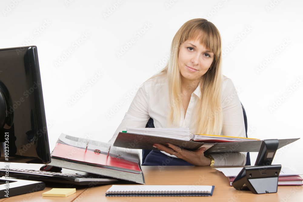 Office a specialist wearily leafing through a folder with documents Office a specialist wearily leafing through a folder with documents
