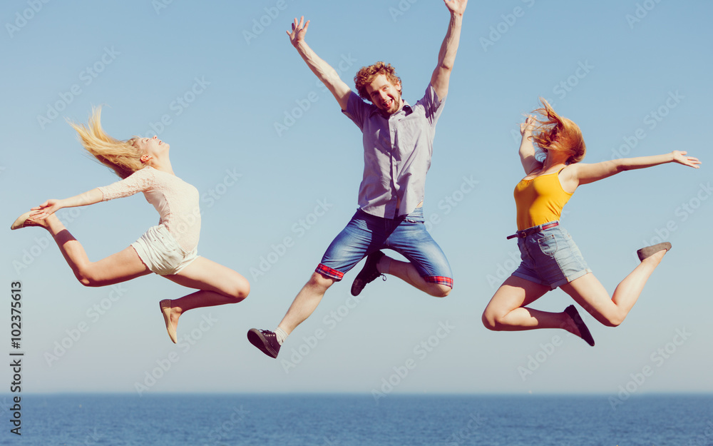 Group of friends boy two girls jumping outdoor Group of friends boy two girls jumping outdoor