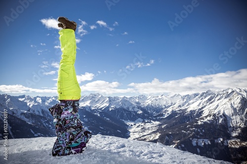 Sporty girl feeling happy in elbowstand at high mountains photo
