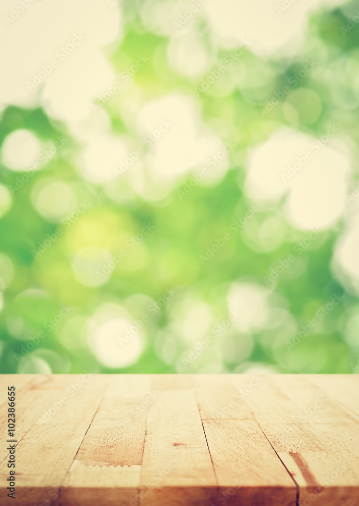 Wood table top on blur bokeh green background, vintage tone Wood table top on blur bokeh green background, vintage tone