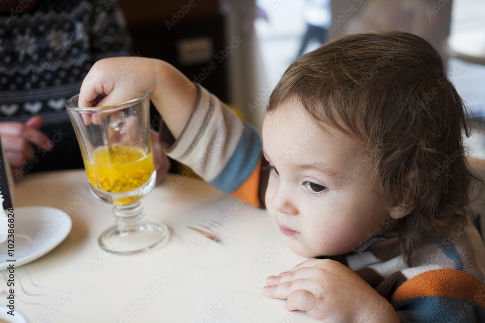 A little boy tries buckthorn tea. A little boy tries buckthorn tea.