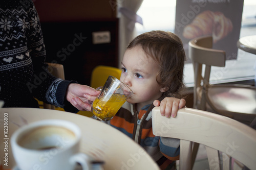 A little boy tries buckthorn tea.