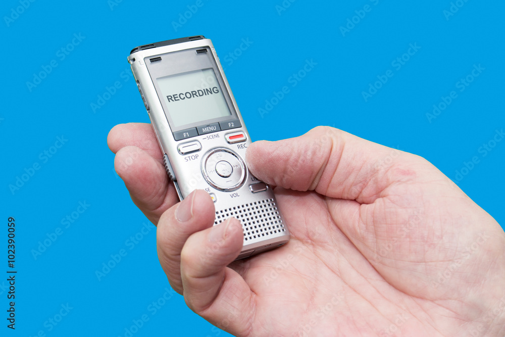 Elderly man is holding voice recorder on blue background, color and contrast manipulated Elderly man is holding voice recorder on blue background, color and contrast manipulated
