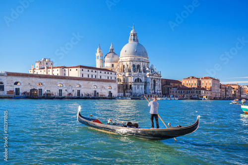 Fotografie Grand Canal and Basilica Santa Maria della Salute with gondolier in Venice, Ital
