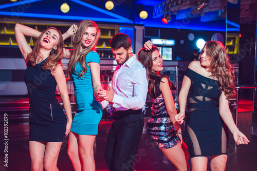 Beautiful girls and man having fun at a party in nightclub