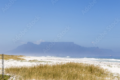 Sunny day at the white sand beach in South Africa. Cape Town and Table Mountain in the background.  