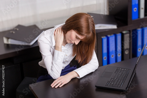 Young beautiful businesswoman has pain in the neck.