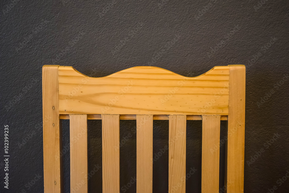 brown wooden chair backrest, black gray cement background brown wooden chair backrest, black gray cement background