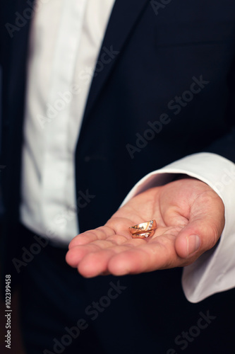 wedding rings in hands at the groom