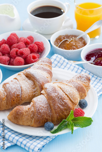 breakfast with croissants  jams  fresh berries and orange juice