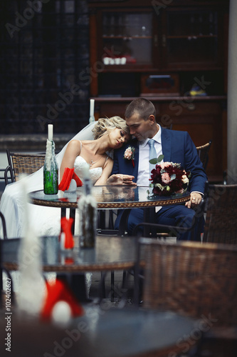 Romantic relaxed newlywed couple sitting at restaurant table