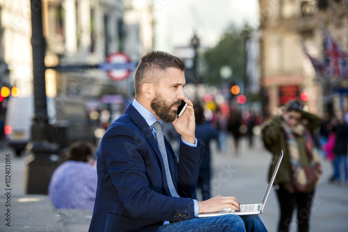 фотография Manager with laptop and smart phone, sunny Piccadilly Circus, Lo