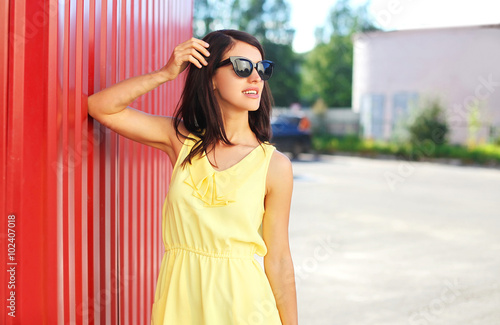 Fashion beautiful woman wearing a yellow dress and sunglasses in