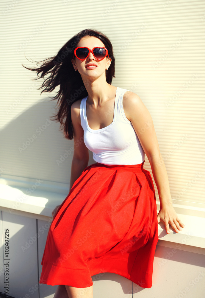 Pretty brunette woman wearing a red sunglasses and skirt in city Pretty brunette woman wearing a red sunglasses and skirt in city
