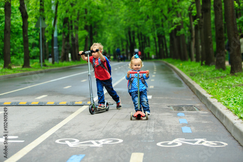 Wallpaper Mural cute little boy and toddler girl riding scooters Torontodigital.ca