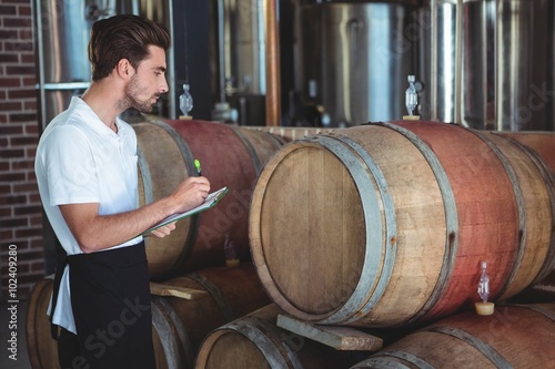 Winemaker taking notes on clipboard photo