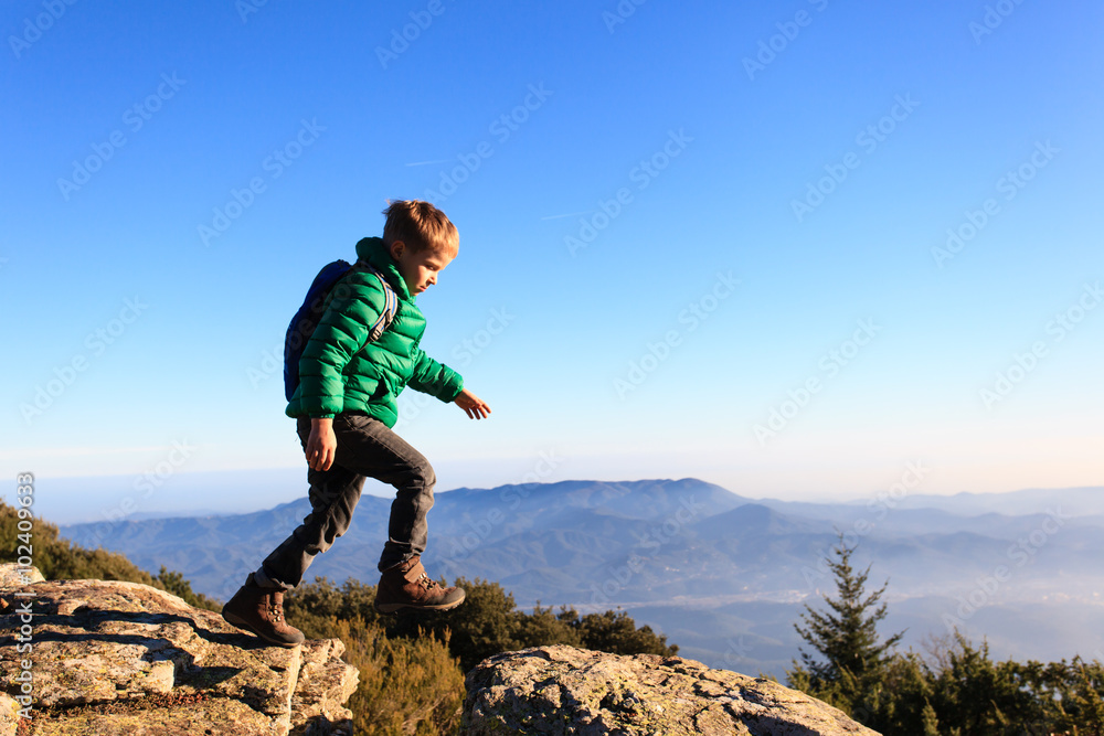 little boy hiking in scenic mountains