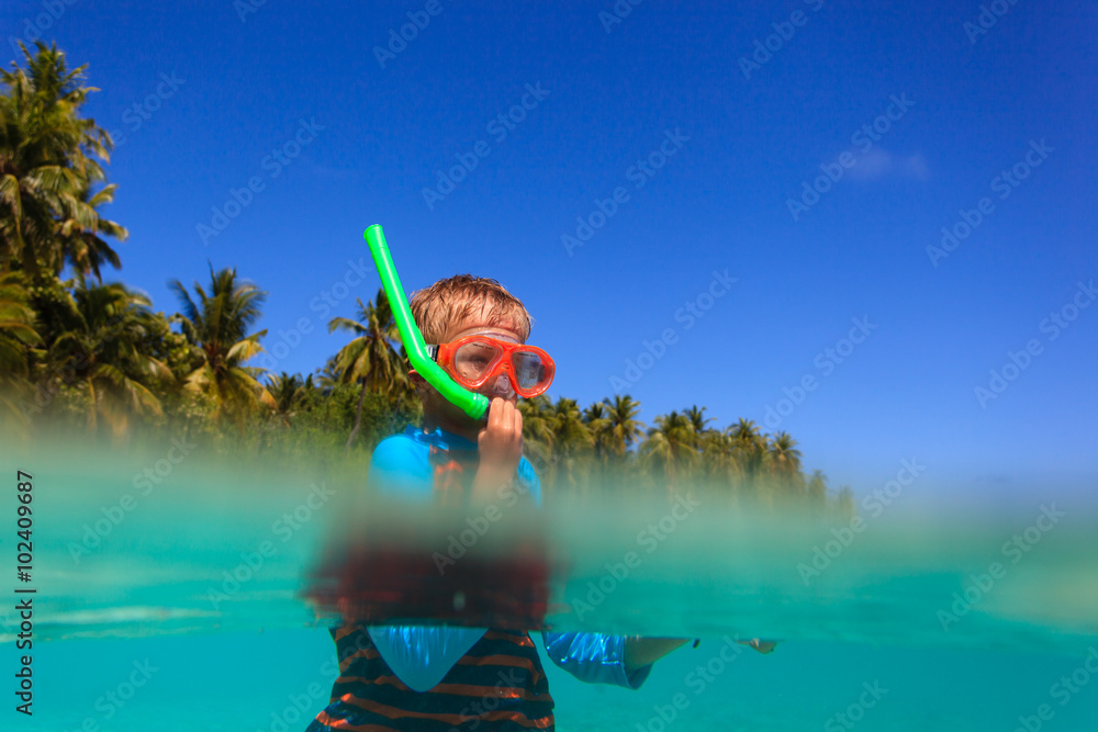cute boy swimming and snorkeling in ocean