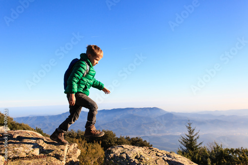little boy hiking in scenic mountains