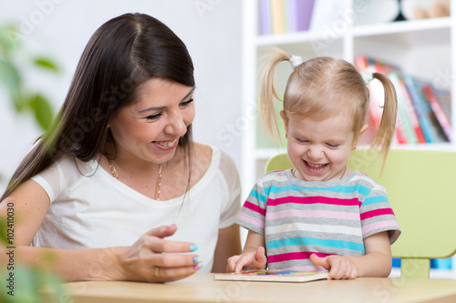 kid and mother play together with puzzle toy