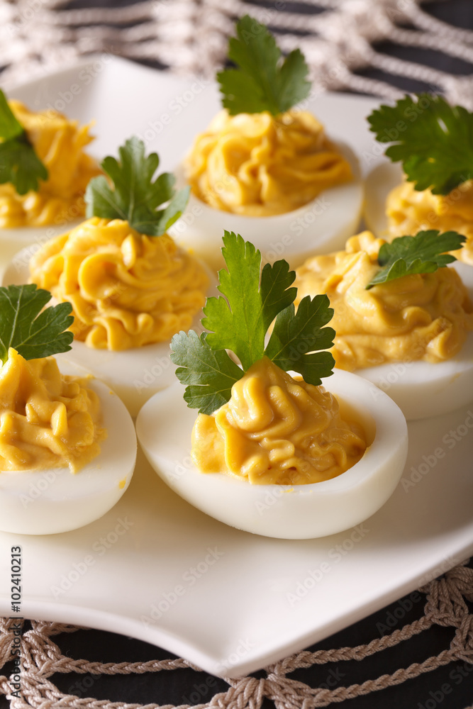 Appetizer stuffed eggs with mustard and parsley close-up. vertical
Appetizer stuffed eggs with mustard and parsley close-up. vertical