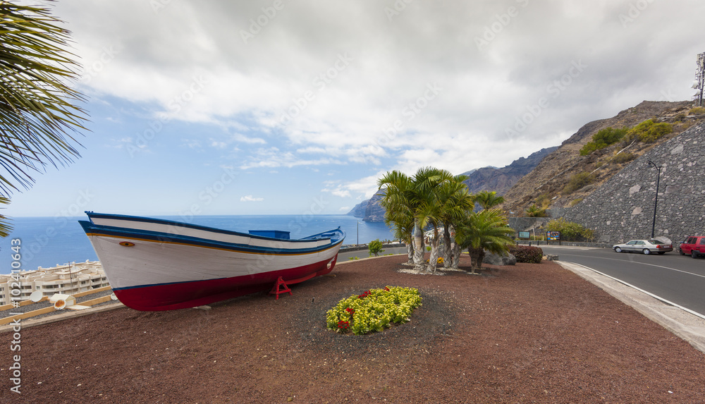 Restored fishing boat, behind the rock group los Gigantes in Puerto de Santiago, Tenerife, Canary Islands, Spain, Europe