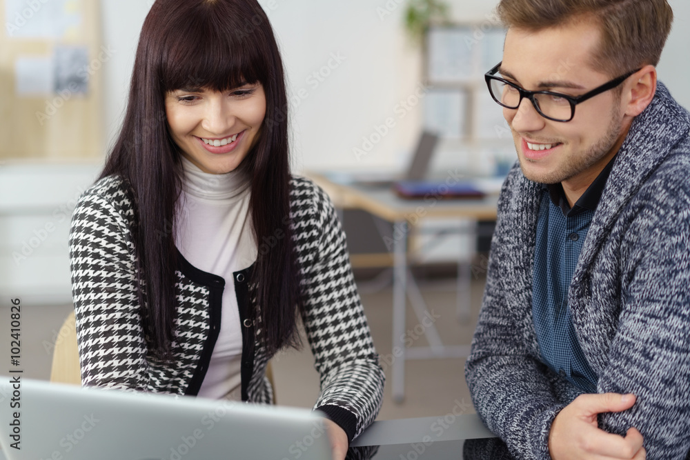 Fototapeta premium junge kollegen schauen gemeinsam auf den laptop