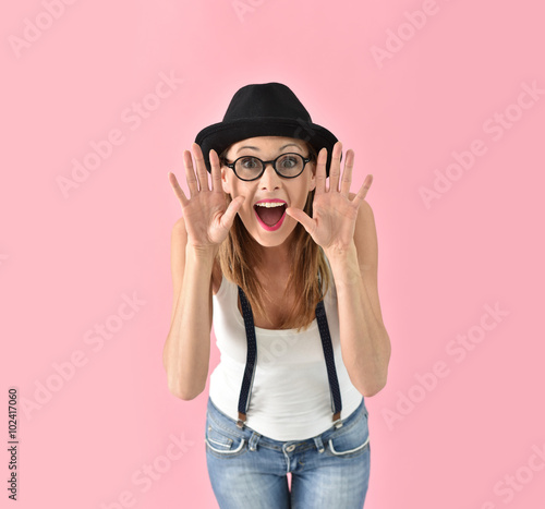 Fashion girl with hat and eyeglasses, isolated on pink background