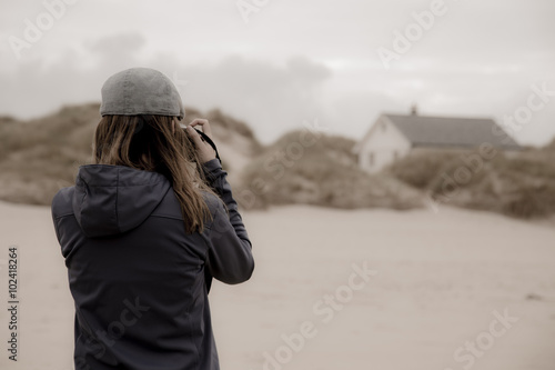 Frau fotografiert Strandhaus