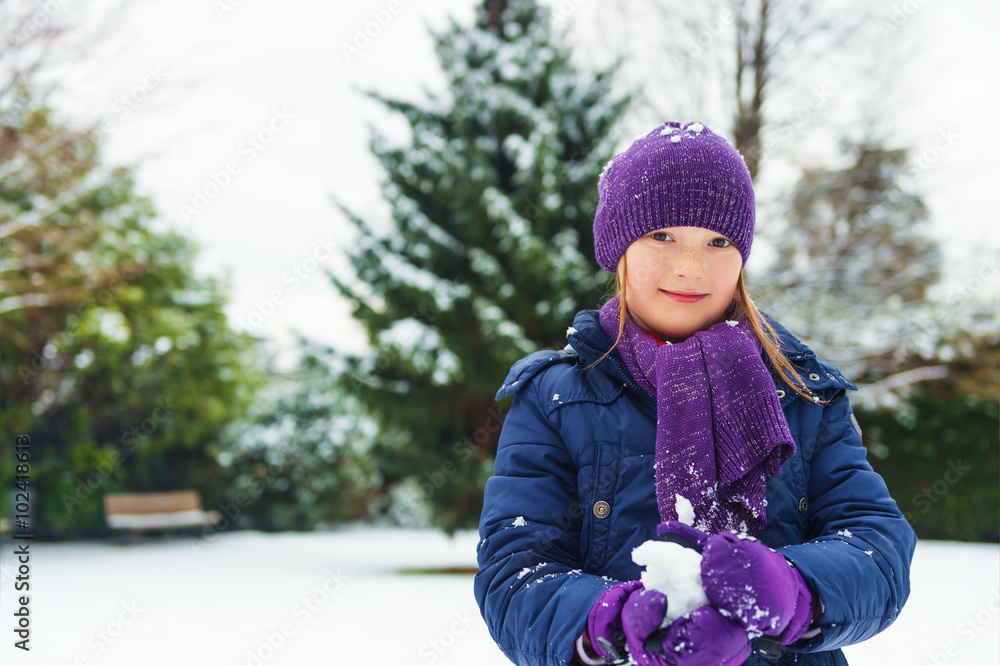Adorable little girl of 8 years old playing in winter park, wearing warm  blue coat, purple set of hat, scarf and gloves Stock Photo | Adobe Stock