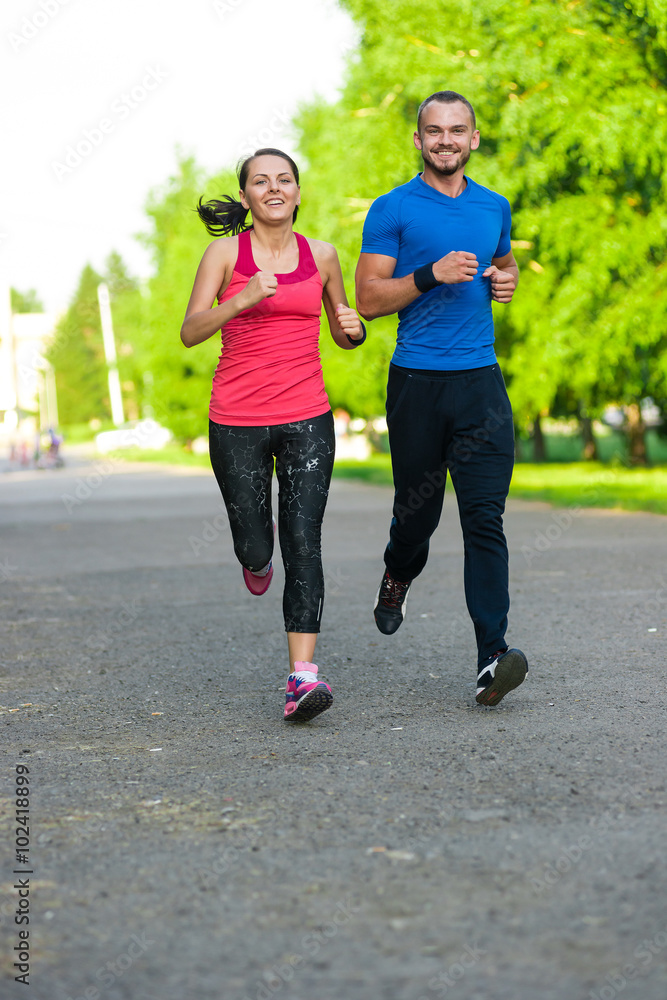 Fototapeta premium Runners training outdoors working out. City running couple jogging outside.