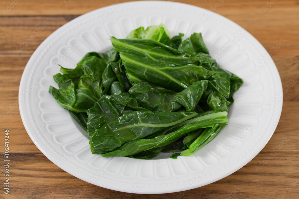 boiled cabbage on white plate on brown wooden background boiled cabbage on white plate on brown wooden background