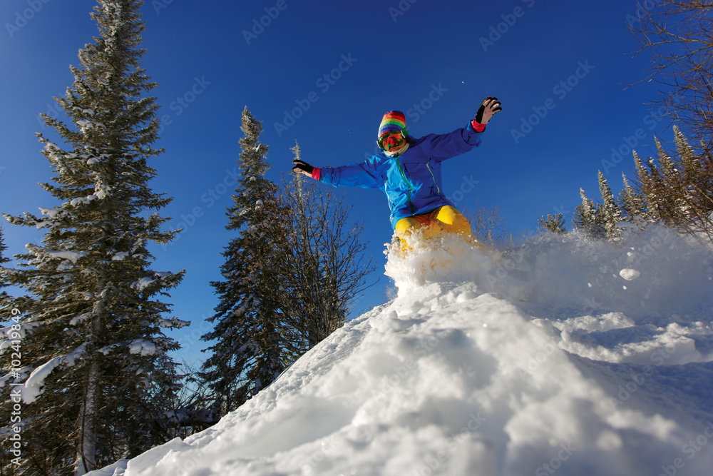 Snowboarder jumping through air with deep blue sky in background Snowboarder jumping through air with deep blue sky in background