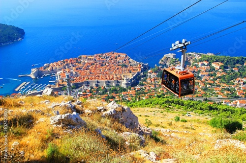 Cable car with tourists and Dubrovnik Old town in background photo