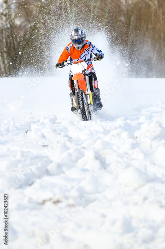 Front view of motocross rider on motorbike in deep snow