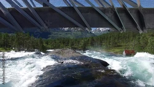 Flying under the bridge above waterfall Likholefossen, popular tourist attraction on national tourist route Gaularfjellet in Norway. Aerial 4k Ultra HD. photo