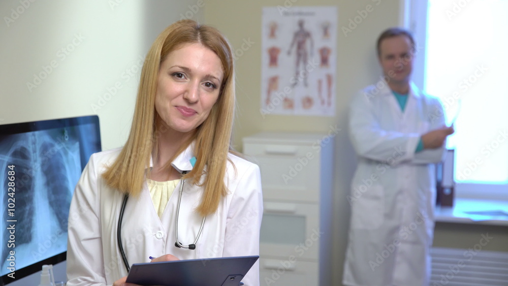 Young attractive female doctor and a male doctor looking at the camera and smiling. 4k Young attractive female doctor and a male doctor looking at the camera and smiling. 4k