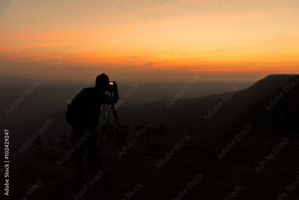 Silhouette of photographer when he is taking photograph on mountain