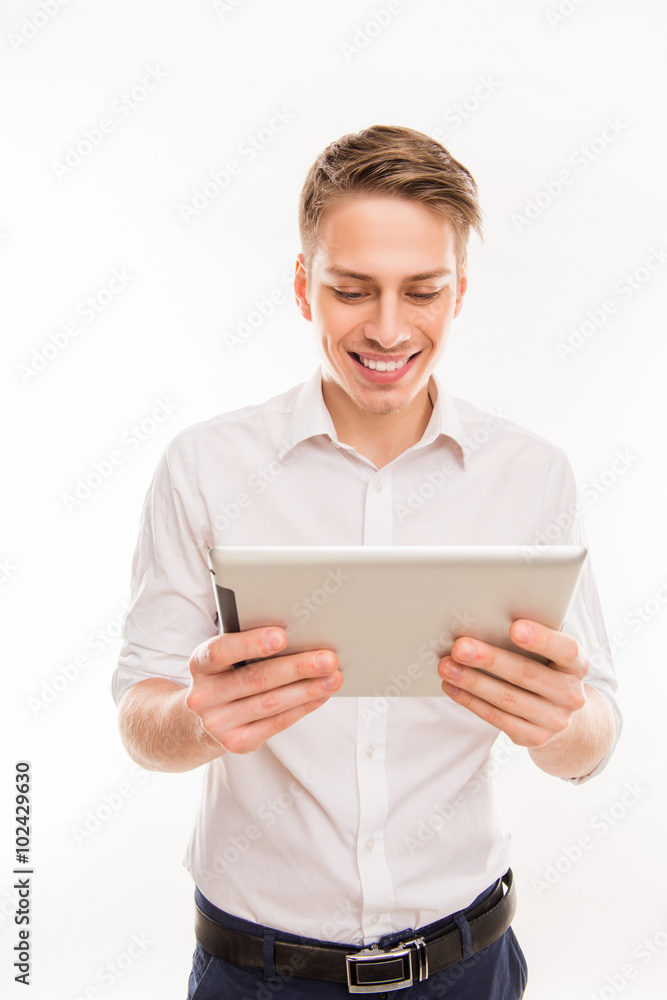 Pretty young businessman holding tablet and reading news Pretty young businessman holding tablet and reading news