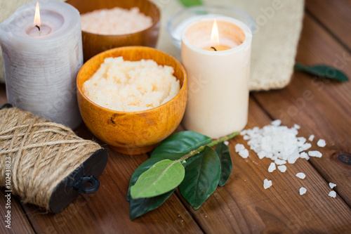 close up of natural body scrub and candles on wood