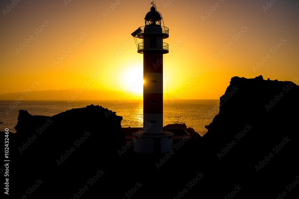 Coastline with lighthouse silhouette