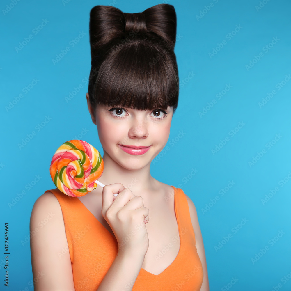 Naklejka premium Smiling teen girl with colourful lollipop. Attractive Funny brun